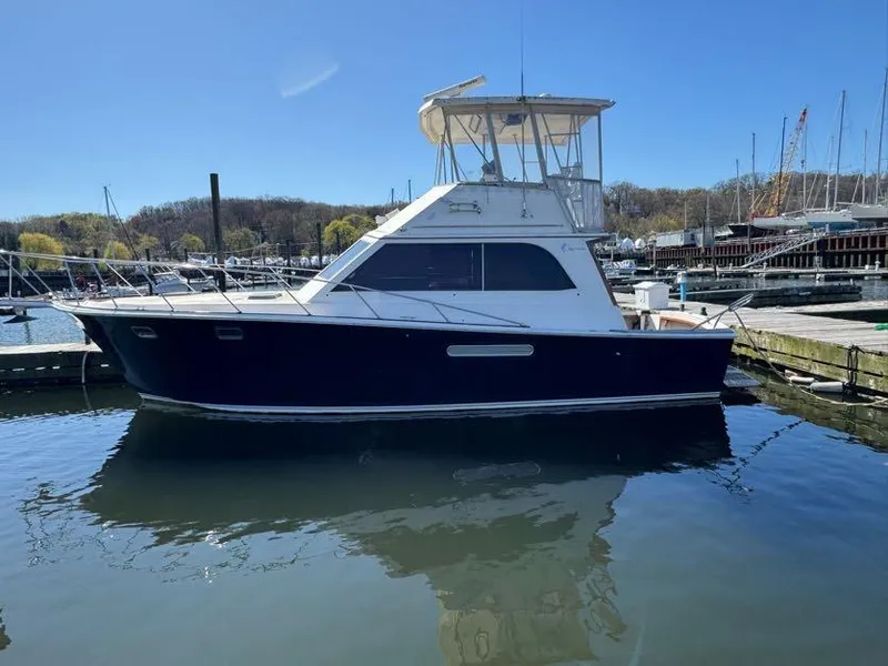 Slide: The Image of 1985 Egg Harbor 37 Convertible yacht docked in a marina on a sunny day. - 2