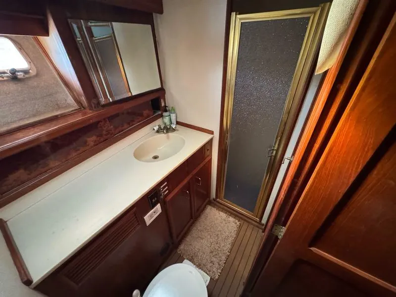 Slide: The Image of 1985 Egg Harbor 37 Convertible yacht bathroom with sink, mirror, and shower. - 24