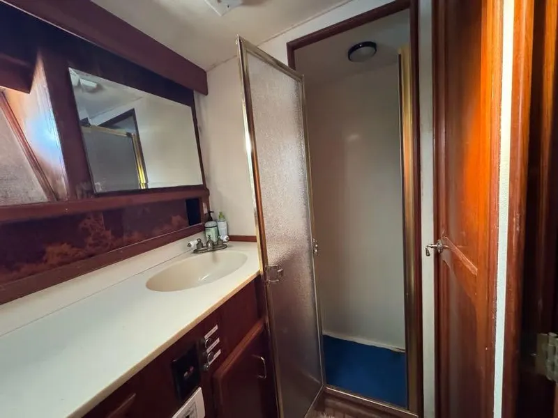 Slide: The Image of 1985 Egg Harbor 37 Convertible yacht bathroom with sink, mirror, and shower. - 25