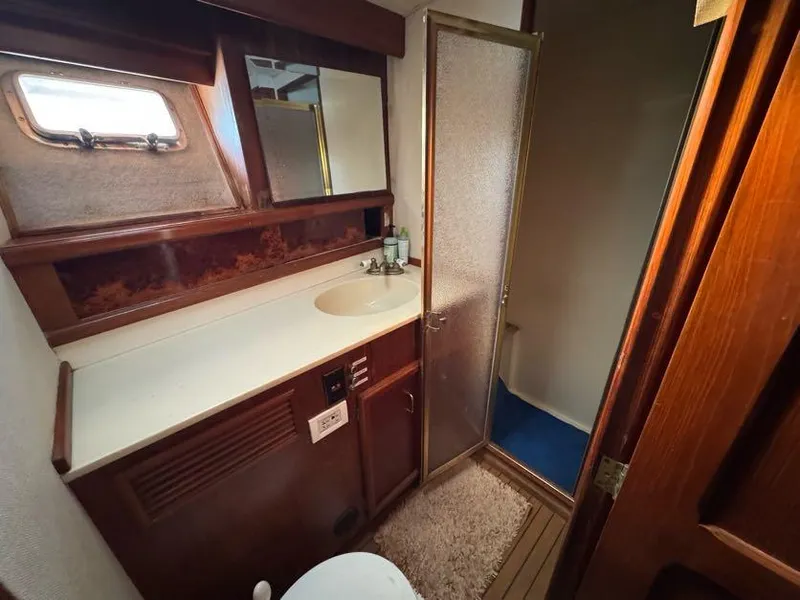 Slide: The Image of 1985 Egg Harbor 37 Convertible yacht bathroom with sink, mirror, and shower. - 26