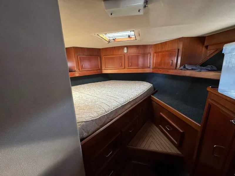 Slide: The Image of 1985 Egg Harbor 37 Convertible cabin with wooden cabinetry and a cozy bed. - 28