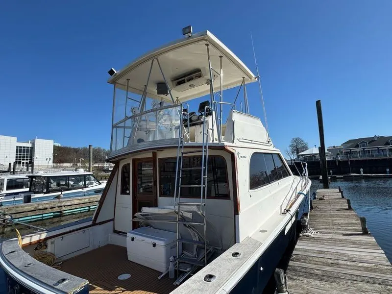 Slide: The Image of 1985 Egg Harbor 37 Convertible yacht docked at marina under clear blue sky. - 5