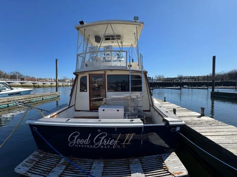 Slide: The Image of 1985 Egg Harbor 37 Convertible boat docked at marina, clear sky, rear view. - 7