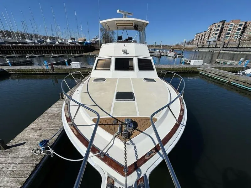 Slide: The Image of 1985 Egg Harbor 37 Convertible yacht docked in a marina, showcasing its sleek design. - 8
