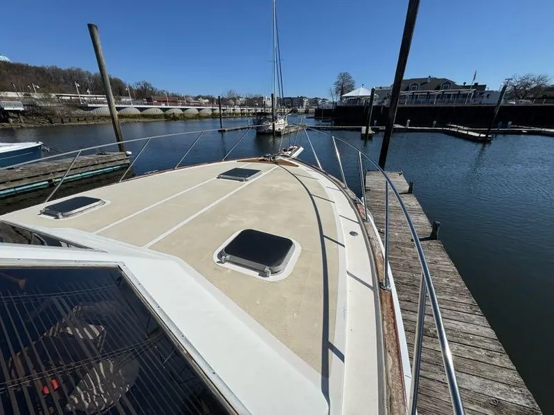 Slide: The Image of 1985 Egg Harbor 37 Convertible boat docked in a marina, clear sky, calm water. - 9