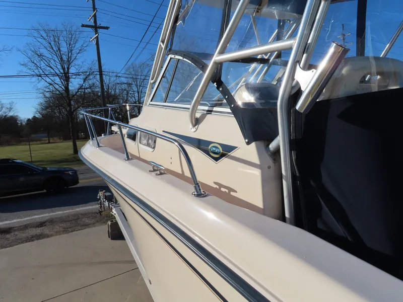 Slide: The Image of 2006 Grady-White Journey 258 boat, side view, showcasing sleek design and sturdy railings. - 7