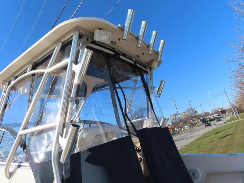 Slide: The Image of 2006 Grady-White Journey 258 boat with clear canopy and rod holders, under a bright blue sky. - 8