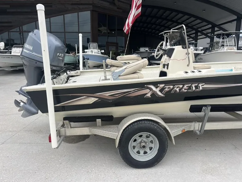 Slide: The Image of 2013 Xpress XP20 CC boat on trailer with Yamaha 115 engine, parked outdoors. - 11