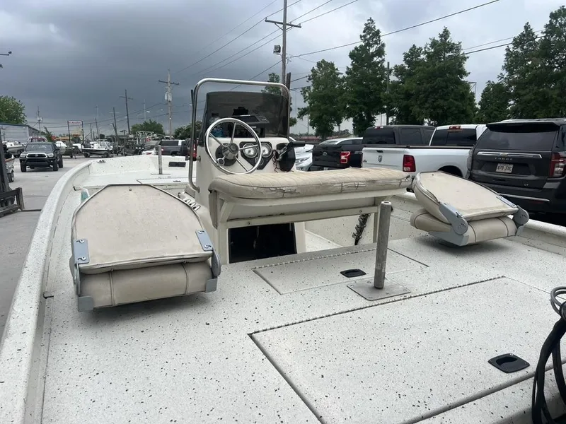 Slide: The Image of 2013 Xpress XP20 CC boat with seating, parked outdoors under cloudy skies. - 12