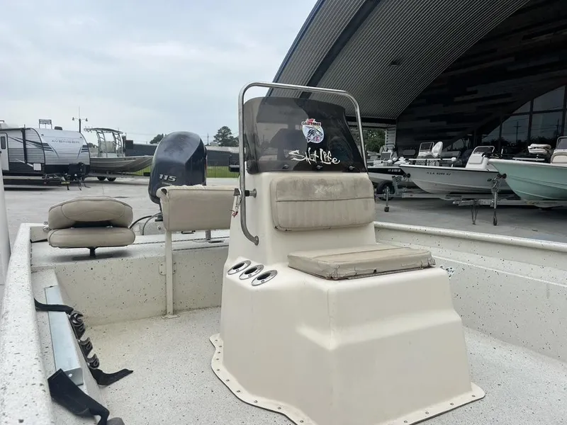 Slide: The Image of 2013 Xpress XP20 CC boat with console and seating, parked near other boats and trailers. - 4