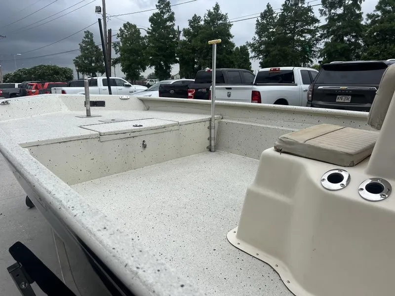 Slide: The Image of 2013 Xpress XP20 CC boat interior with seating, parked outdoors. - 5