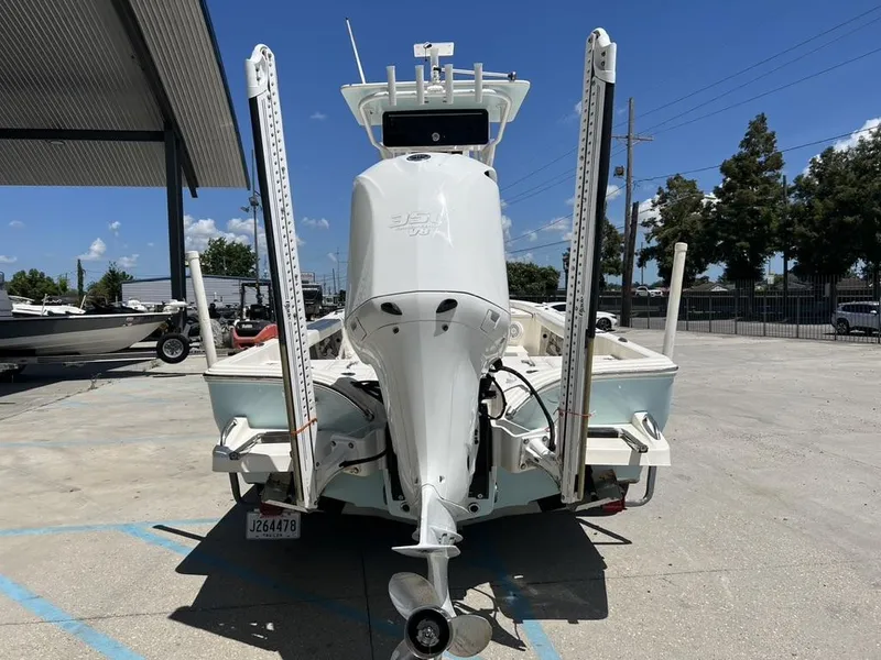 Slide: The Image of 2016 Avenger AV 26 boat with outboard motor, parked outdoors under clear blue sky. - 11