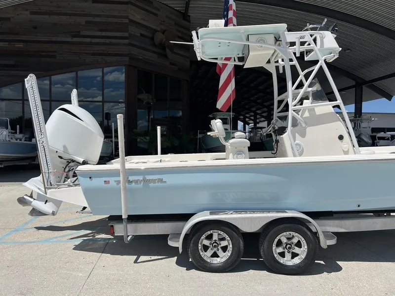 Slide: The Image of 2016 Avenger AV 26 boat on trailer with American flag, parked outdoors. - 19