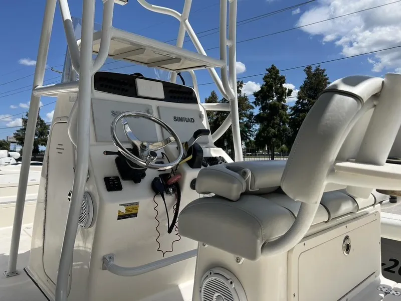 Slide: The Image of 2016 Avenger AV 26 boat console with steering wheel and seating under clear blue sky. - 4