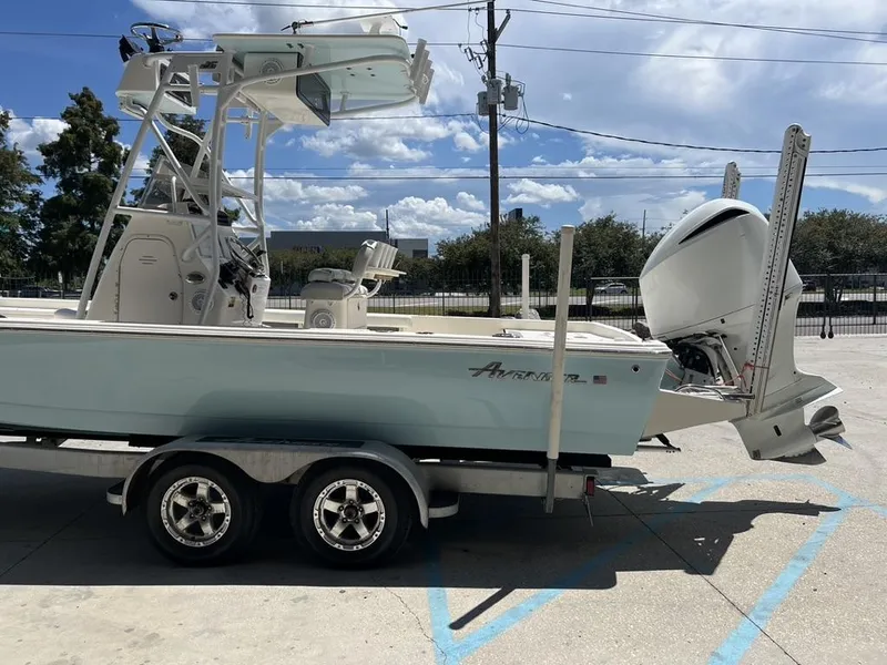 Slide: The Image of 2016 Avenger AV 26 boat on trailer, parked outdoors under a clear sky. - 8