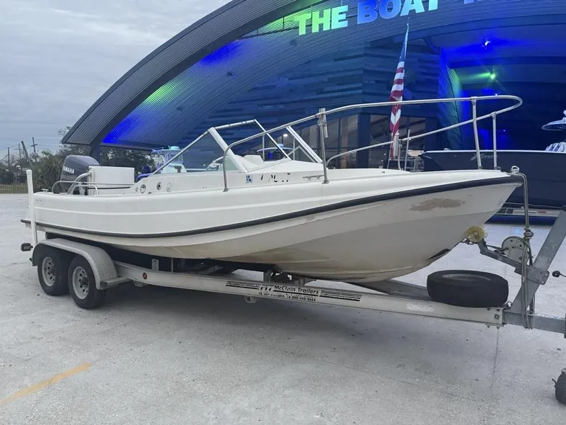 Slide: The Image of 1977 Boston Whaler 21 REVENGE boat on trailer, parked outside a showroom. - 7
