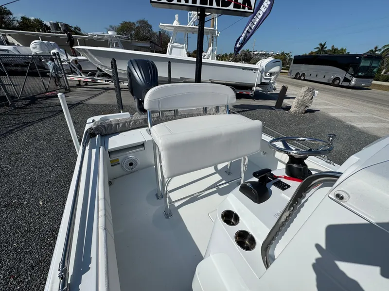 Slide: The Image of 2023 Contender 25 Bay boat interior with seating and steering wheel, displayed outdoors. - 11