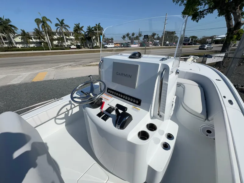 Slide: The Image of 2023 Contender 25 Bay boat console with Garmin navigation system, steering wheel, and controls. - 12
