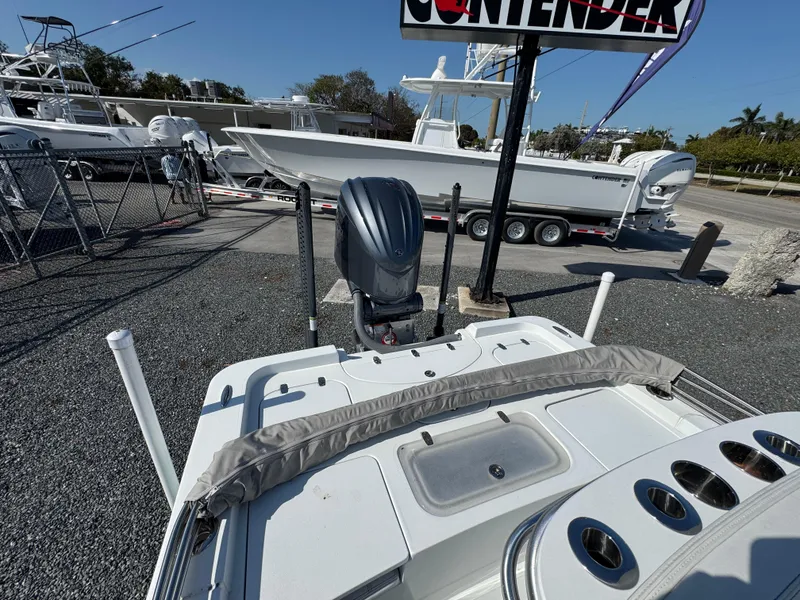 Slide: The Image of 2023 Contender 25 Bay boat displayed outdoors with motor and fishing rod holders. - 13