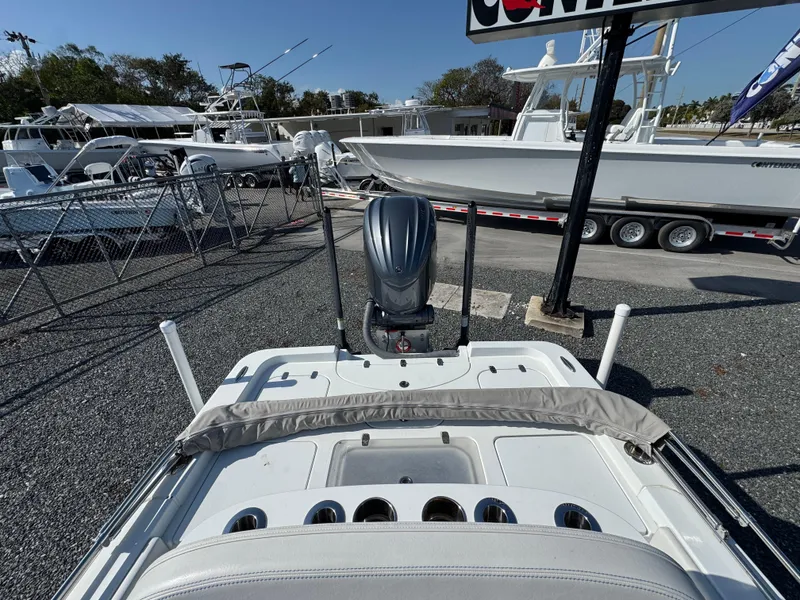 Slide: The Image of 2023 Contender 25 Bay boat with outboard motor, displayed at a marina. - 15