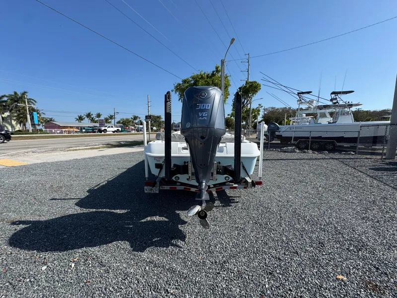 Slide: The Image of 2023 Contender 25 Bay boat with powerful outboard motor on a gravel lot. - 5
