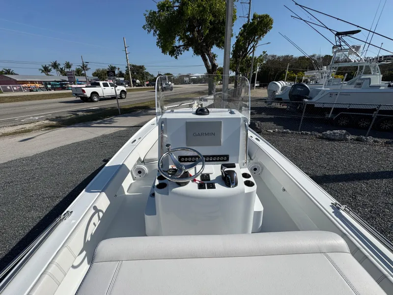 Slide: The Image of 2023 Contender 25 Bay boat with Garmin navigation, parked on gravel near road and trees. - 6