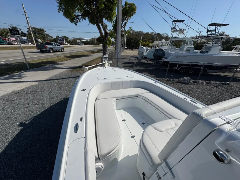 Slide: The Image of 2023 Contender 25 Bay boat with sleek white interior, parked outdoors near a road. - 7