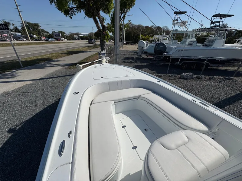 Slide: The Image of 2023 Contender 25 Bay boat with white seating, displayed outdoors. - 8