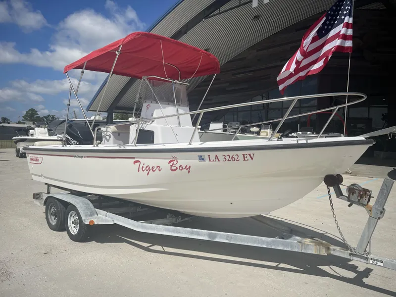 Slide: The Image of 1997 Boston Whaler 21 Outrage boat with red canopy and American flag on trailer. - 19