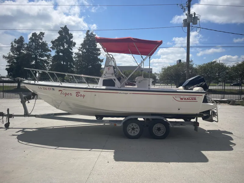 Slide: The Image of 1997 Boston Whaler 21 Outrage boat with red canopy on trailer, side view. - 5