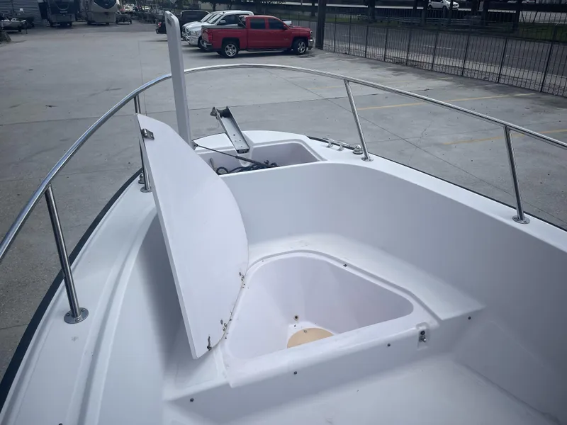 Slide: The Image of 1997 Boston Whaler 21 Outrage boat with open storage compartment, parked in a lot. - 6