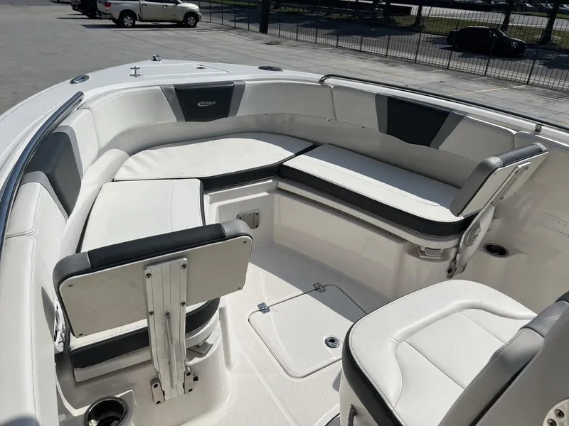 Slide: The Image of 2023 Robalo 230 boat interior with white and gray seating, docked outdoors. - 14