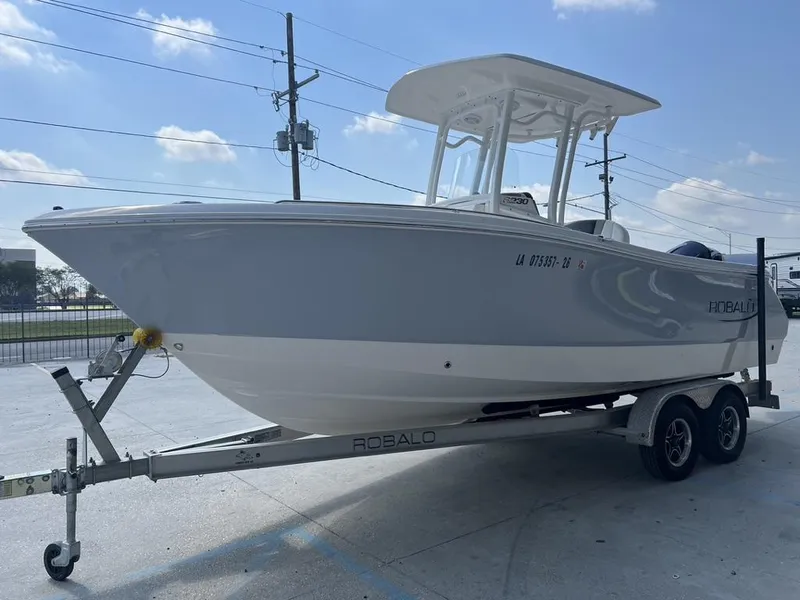 Slide: The Image of 2023 Robalo 230 boat on trailer, parked outdoors under a clear sky. - 3