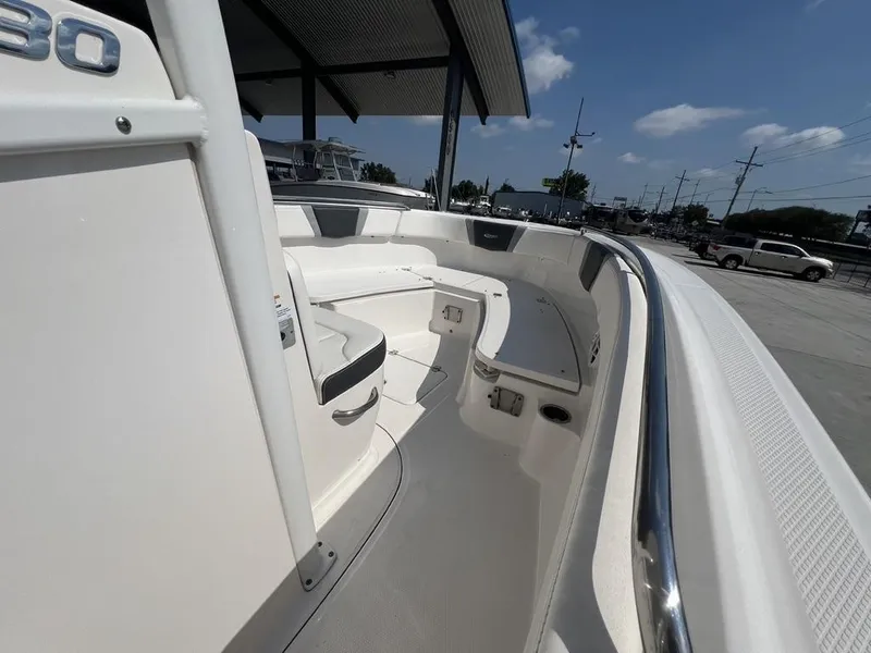Slide: The Image of 2023 Robalo 230 boat interior with seating, under a clear blue sky. - 4