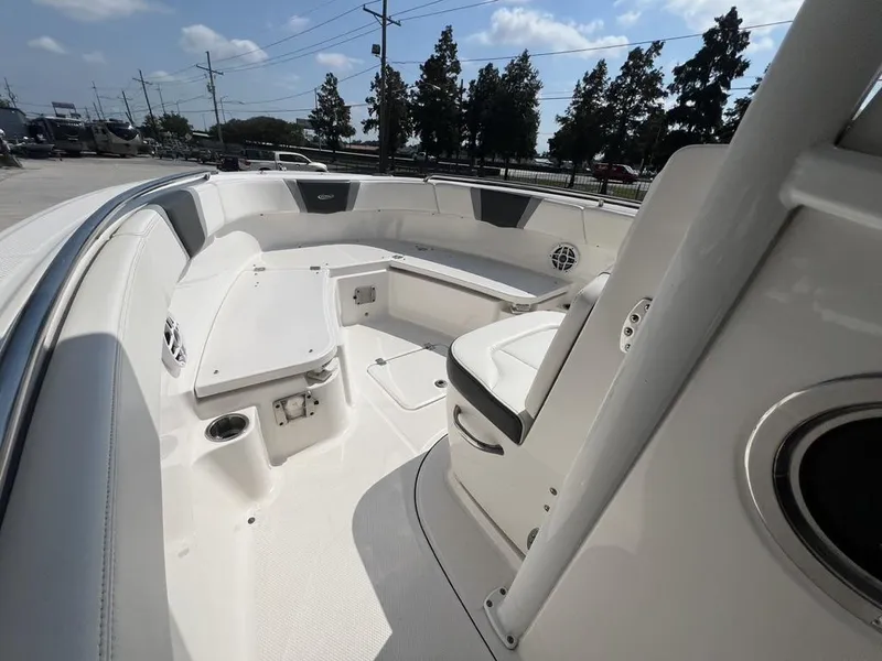 Slide: The Image of 2023 Robalo 230 boat interior with seating and storage compartments under a clear blue sky. - 5