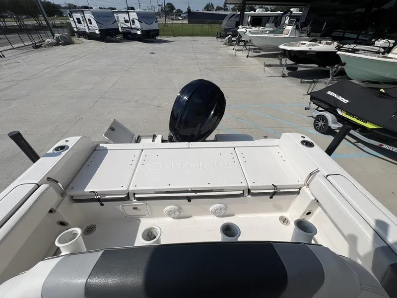 Slide: The Image of 2023 Robalo 230 boat interior with motor, parked near RVs and other boats. - 8