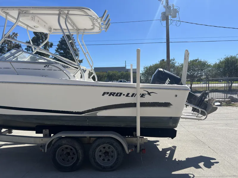 Slide: The Image of 2007 Pro-Line 21 WA boat with outboard motor in a sunny marina setting. - 11