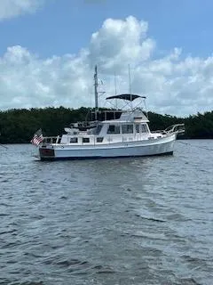Slide: The Image of 1989 Grand Banks GND01 yacht on calm water under a partly cloudy sky. - 10