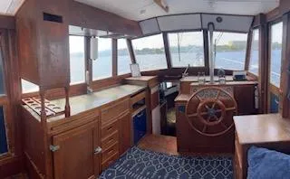 Slide: The Image of 1989 Grand Banks GND01 boat interior with wooden helm, cabinets, and panoramic windows. - 12