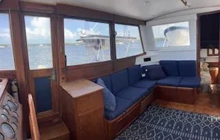 Slide: The Image of 1989 Grand Banks GND01 yacht interior with blue seating and wooden accents. - 13