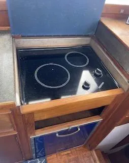 Slide: The Image of 1989 Grand Banks GND01 kitchen with electric stovetop, featuring two burners and wooden cabinetry. - 14