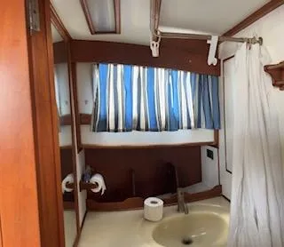 Slide: The Image of 1989 Grand Banks GND01 yacht bathroom with striped curtains and wooden accents. - 17