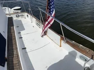 Slide: The Image of 1989 Grand Banks GND01 boat deck with American flag, docked on calm water. - 25