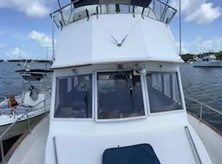 Slide: The Image of 1989 Grand Banks GND01 boat on water, clear sky, other boats in background. - 6