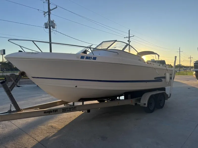 Slide: The Image of 2002 Pro-Line 22DC boat on trailer at sunset, parked outdoors. - 10