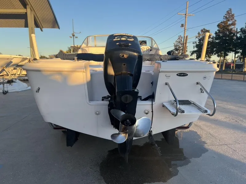 Slide: The Image of 2002 Pro-Line 22DC boat with outboard motor, docked on a sunny day. - 11