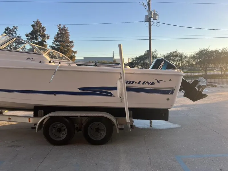 Slide: The Image of 2002 Pro-Line 22DC boat on trailer, parked outdoors at sunset. - 12