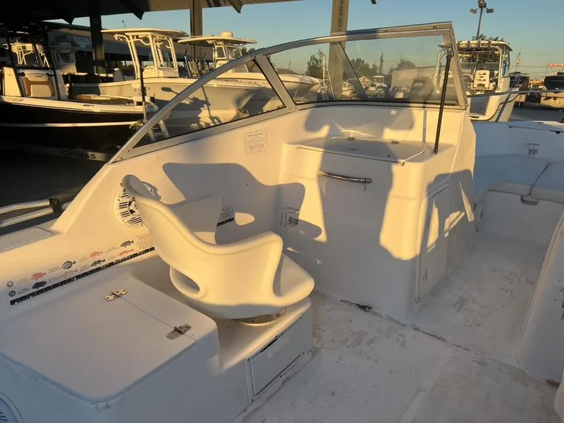 Slide: The Image of 2002 Pro-Line 22DC boat interior with helm and seating, under warm sunlight. - 4