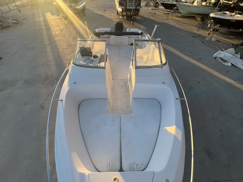 Slide: The Image of 2002 Pro-Line 22DC boat in a sunlit marina, showcasing its deck and windshield. - 7