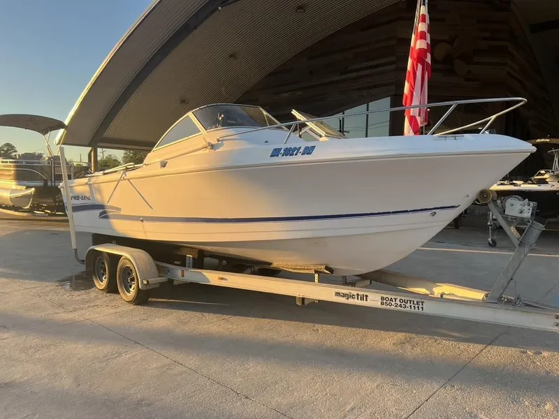 Slide: The Image of 2002 Pro-Line 22DC boat on trailer, parked outdoors with American flag. - 8
